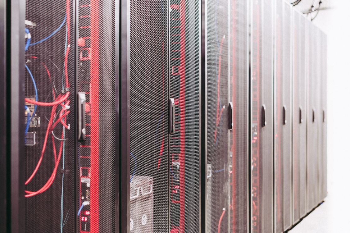Rows of server racks represent the computing infrastructure behind hosted AI model inference